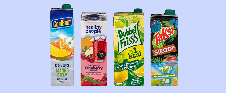 Vier drankverpakkingen met vruchtensap en siroop staan naast elkaar