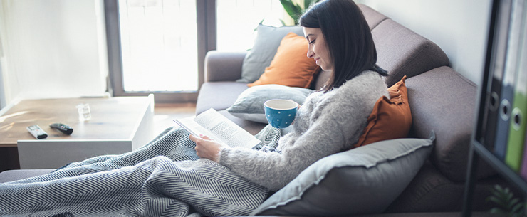 Vrouw leest een boek op de bank