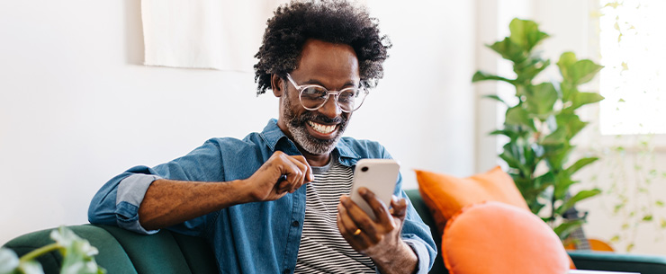 Man kijkt lachtend naar zijn smartphone