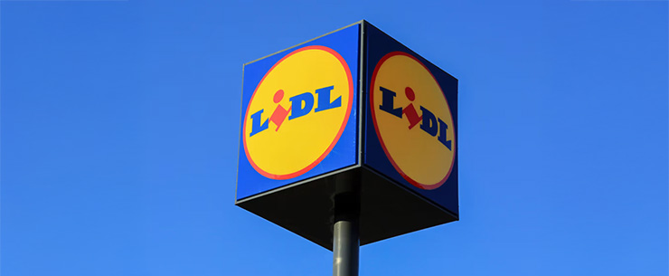 Lidl-logo op een paal tegen een heldere blauwe lucht.