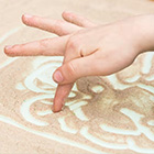 Hand van kind die in speelzand tekent