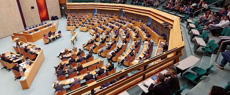 Vergaderzaal van de Tweede Kamer met aanwezige leden tijdens een plenaire bijeenkomst