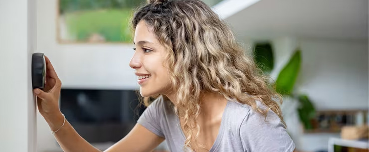 Vrouw draait aan thermostaat