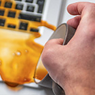 Hand houdt betaalpas boven betaalterminal naast een toetsenbord