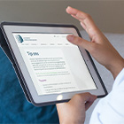 Handen houden tablet vast met formulier op scherm.