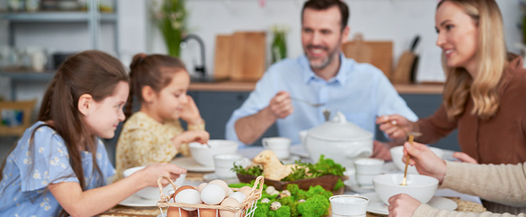 Familie aan tafel en de vrouw pakt een gekookt ei