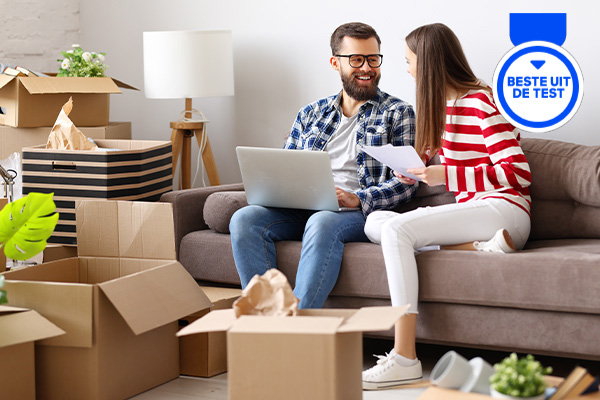 Man en vrouw zitten op een bank tussen verhuisdozen