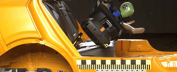 Crashtest met een autostoeltje en testpop in een opengezaagde auto