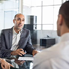 Man die met een klant aan het praten is op een kantoor.