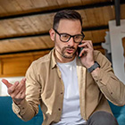 Man voert een telefoongesprek in een binnenruimte