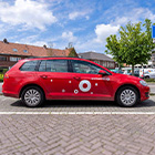 Rode deelauto staat geparkeerd in een woonstraat