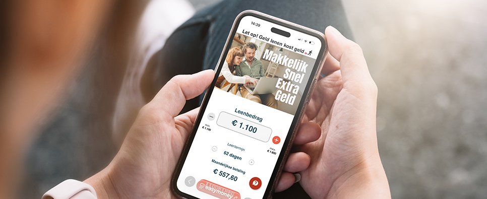 Iemand met een telefoon in de hand met daarop een malafide website, met de tekst Makkelijk Snel Extra Geld en een leenbedrag van 1100 eur met een maandelijkse betaling van 557,60