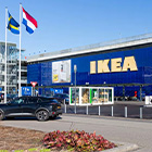 Gevel van een IKEA-winkel met vlaggen en parkeerterrein