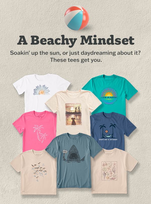 Assortment of Life is Good beach tees in white, cream, teal, pink, blue, and sand, featuring shark, daisy, palm trees, seashells, "Every Day is Saturday," and beach sunset graphics. 