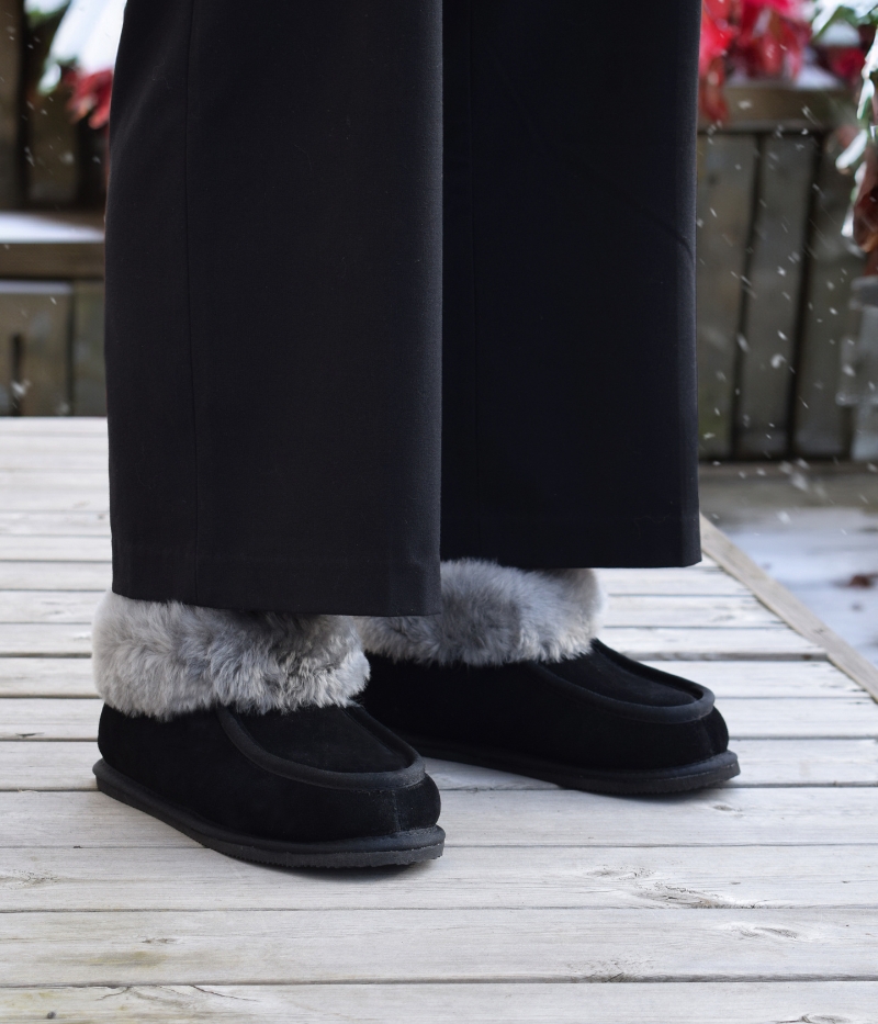 Koster i svart med grått fårskinnsfoder och gummisula