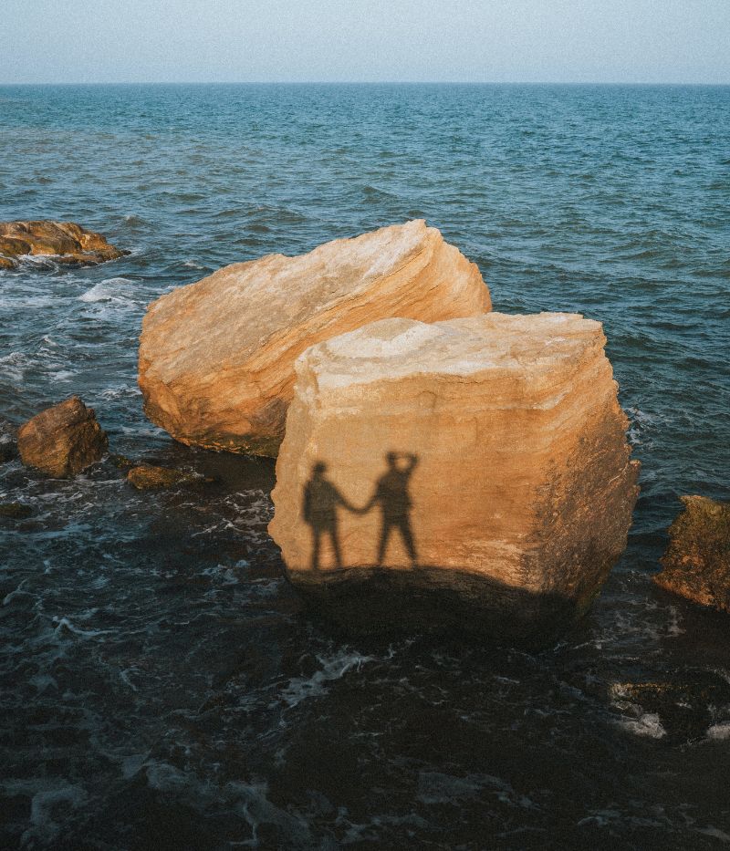Ett par på promenad vid havet bland klippor