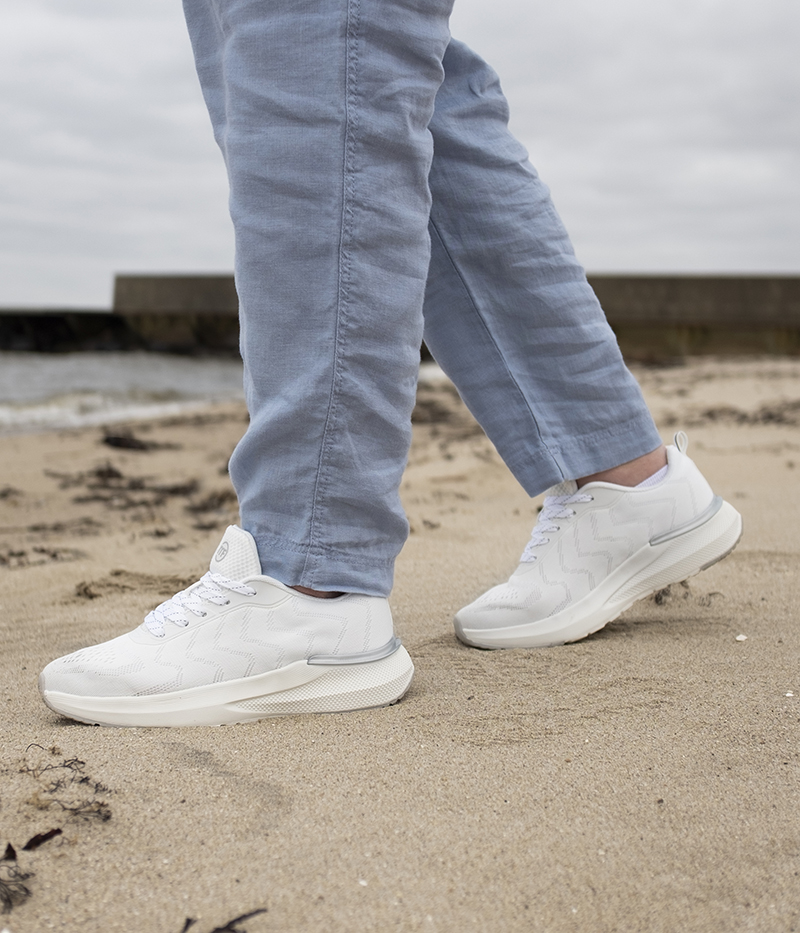 Minfot Move i vitt på strandpromenad