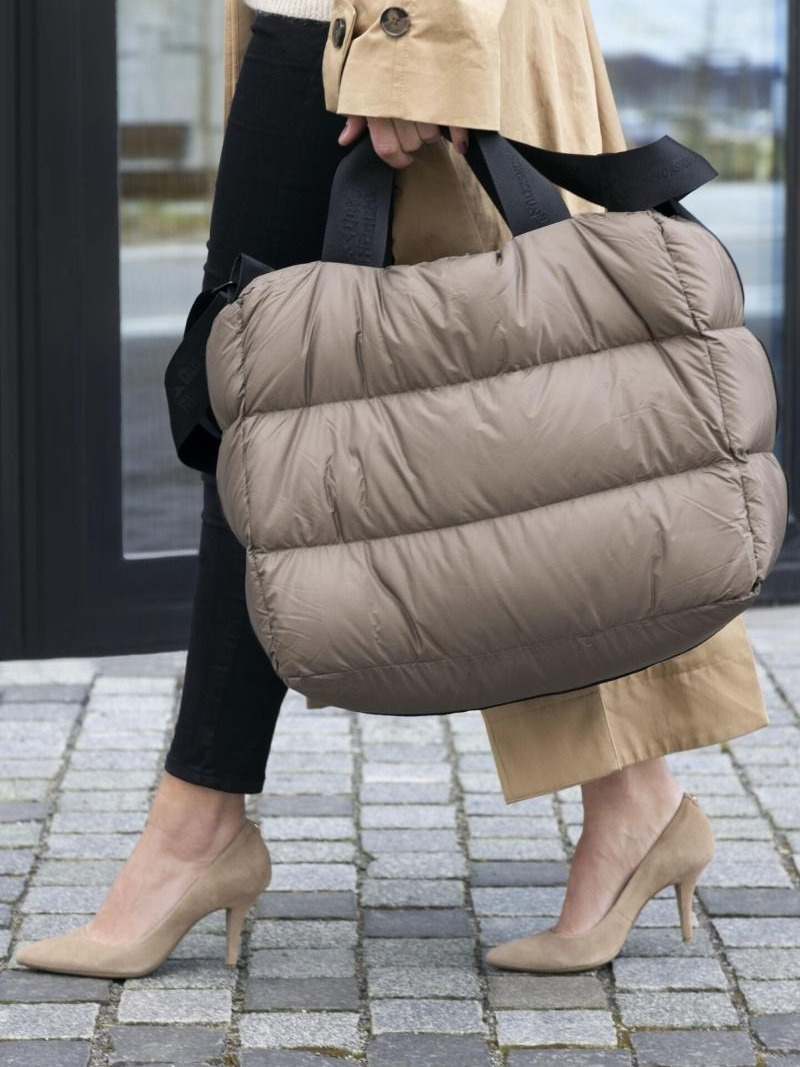 dame med høye hæler som bærer en fancy dunveske