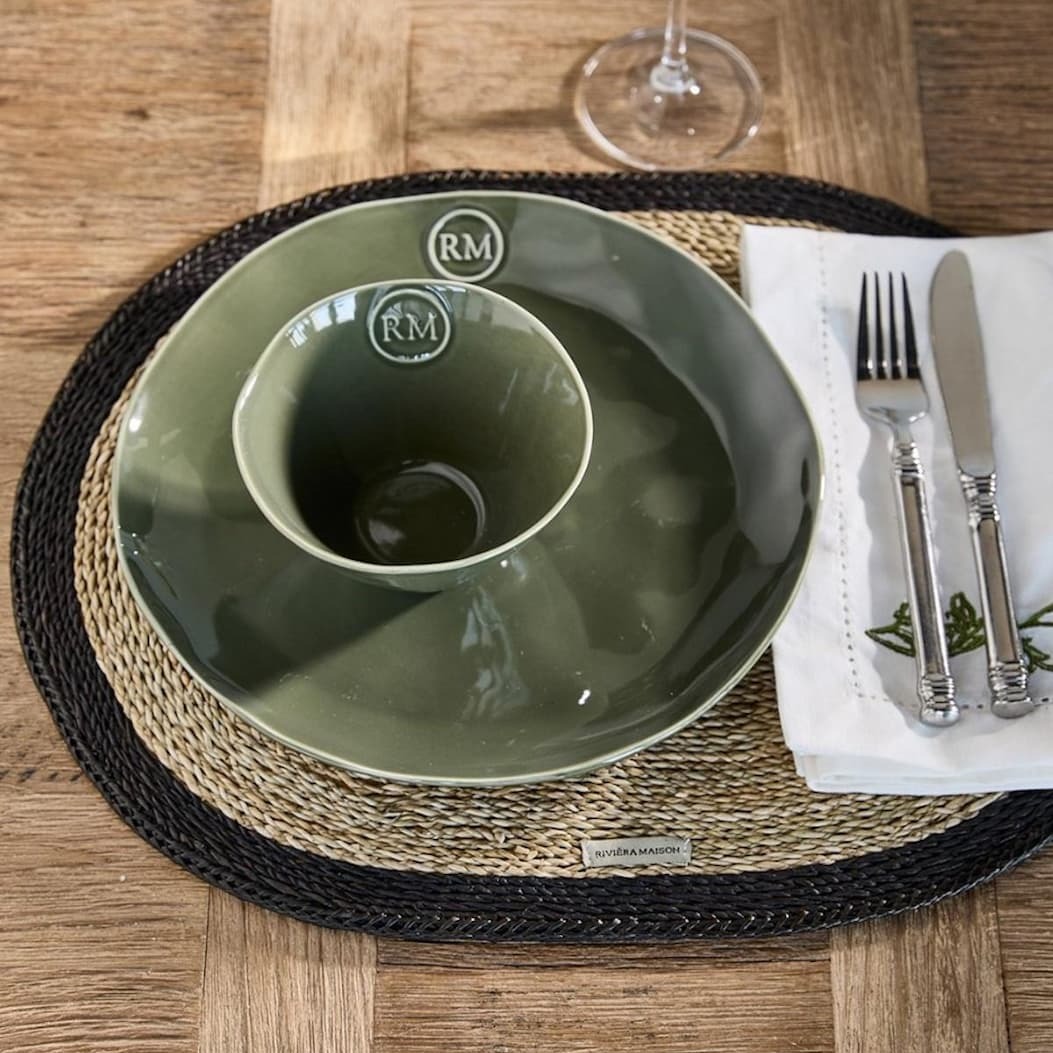 an image of a place setting with a green bowl and a fork and knife