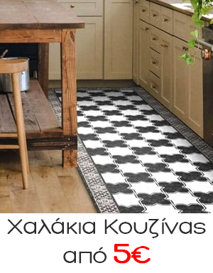 Black-and-white patterned kitchen floor tiles forming a runner between a wooden island and beige cabinets