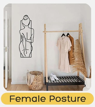 Minimalist hallway with wooden clothes rack holding two dresses, pampas grass, woven basket and line-art female wall sculpture