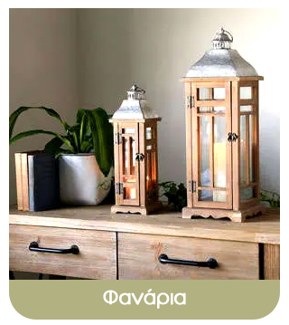 Two decorative wooden lanterns with lit candles on a rustic wooden sideboard beside a potted plant and books