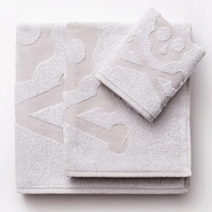 Soft pale grey cotton towels with embossed skull-and-crossbones design, neatly folded on a white background