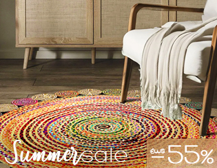 Colourful round braided rug on wooden floor beside armchair with throw, rattan cabinet backdrop and 'Summer sale -55%' overlay