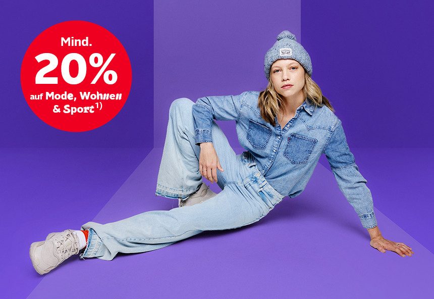 Weibliches Model im Denim-Look, sitzend auf dem Boden, roter Kreis "Mind. 20% auf Mode, Wohnen & Sport".