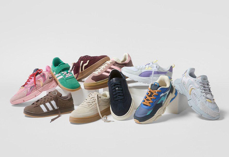 viele verschiedene Sneaker liegen auf einem Haufen vor grauem Hintergrund