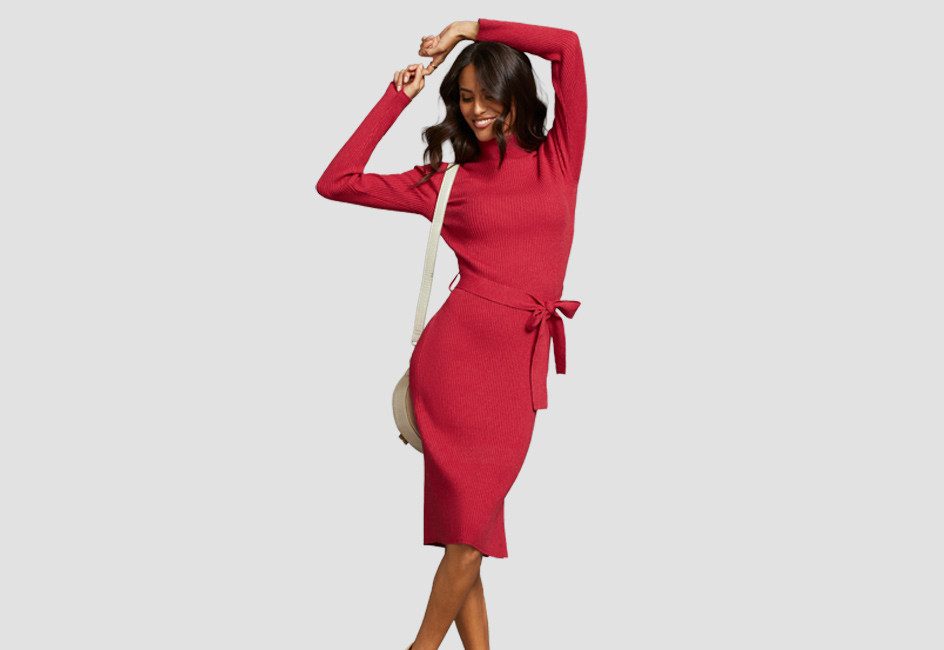 Frau im roten Kleid räkelt sich vor Grau