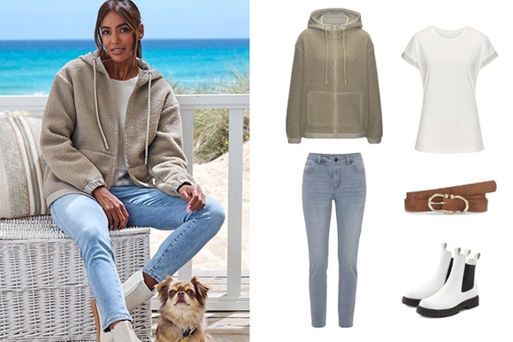 Frau tr&auml;gt eine gr&uuml;ne Fleecejacke, ein wei&szlig;es Shirt und eine blaue Jeans