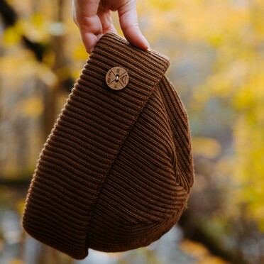 Käsi pitelemässä pipoa.