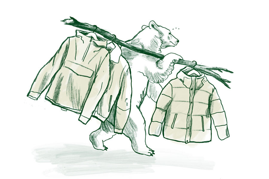 Piirroshahmo karhu kantamassa oksaa, jossa roikkuu takkeja.