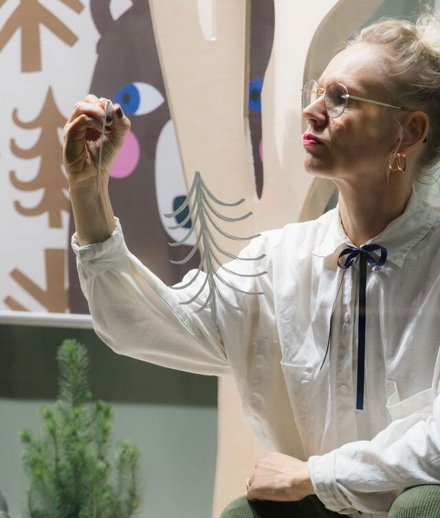 Mira Mallius kuvittamassa Triplan myymälän näyteikkunassa