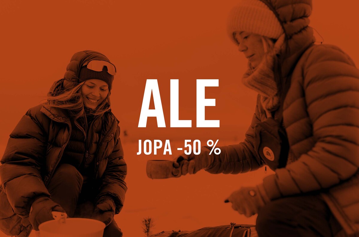 "Ale jopa -50 %" teksti. Taustalla kaksi  naista retkikeittimen &auml;&auml;ress&auml;.
