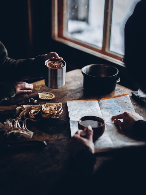 Ihmisi&auml; tuvan p&ouml;yd&auml;n &auml;&auml;ress&auml; katsomassa karttaa