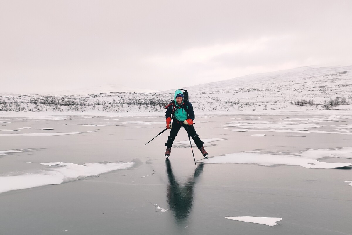 Mies luistelemassa tunturij&auml;rvell&auml;. H&auml;n katsoo suoraan kameraan.