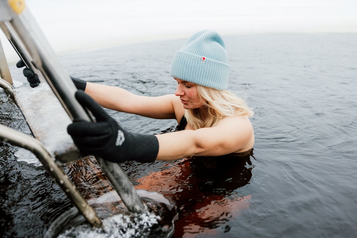 Nainen kipuamassa alas tikkaita avantoon