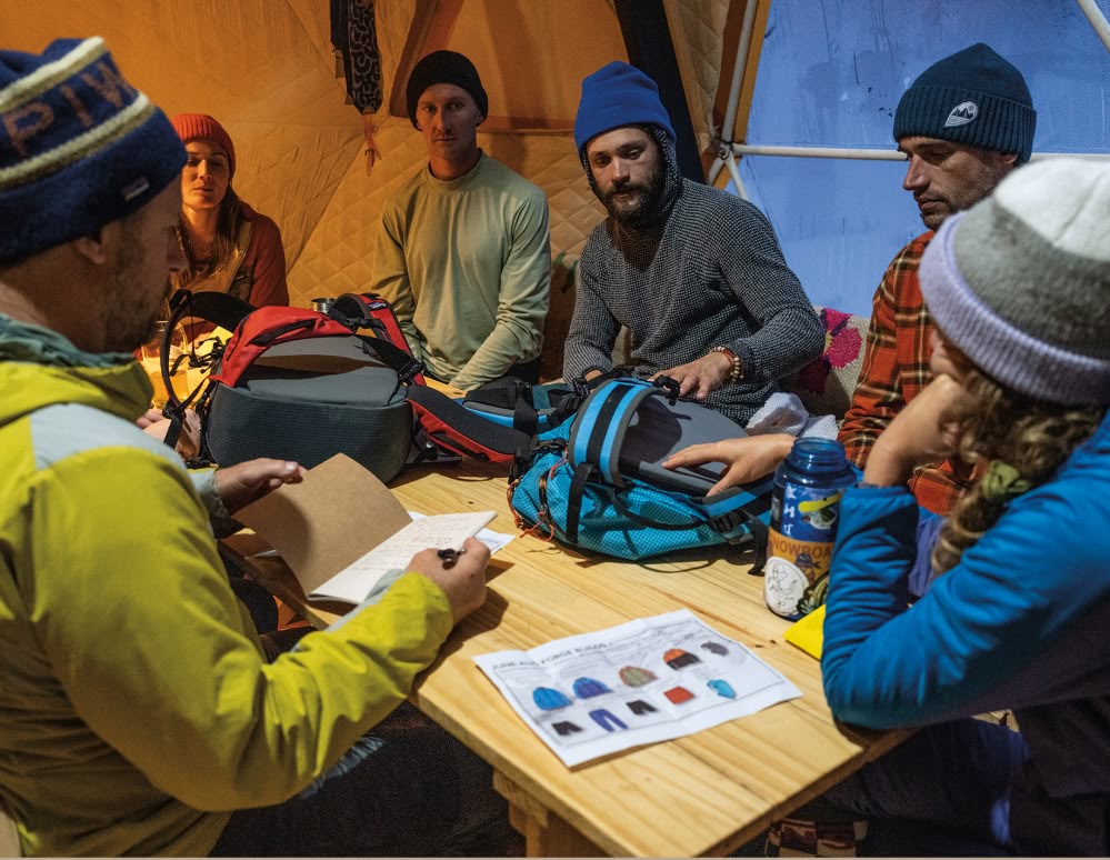 A group of people discuss the details of a backpack.
