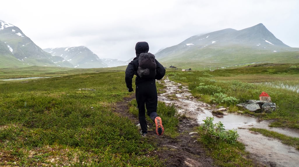 A runner on a wet trail in the tundra.