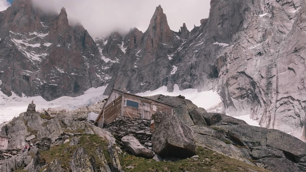 An alpine hut surrounded by granite peaks.