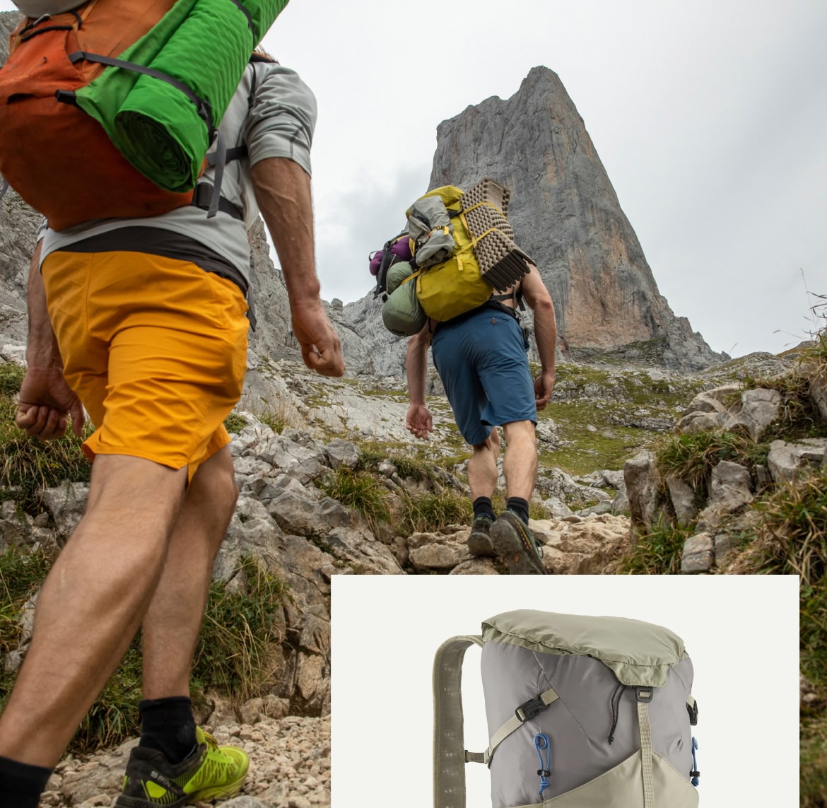 Two climbers with large backpacks hike toward their objective.
