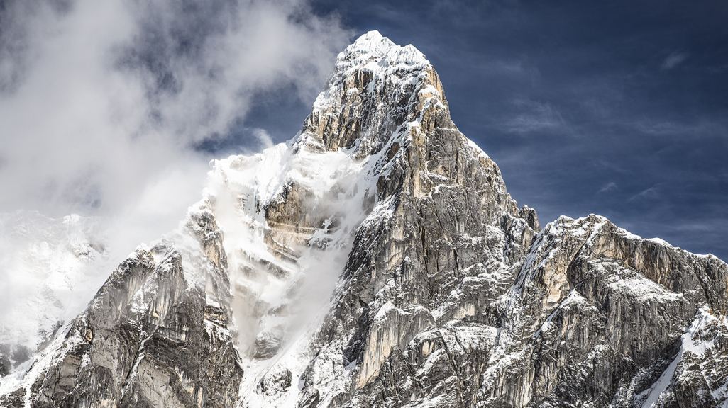 Photo of a gnarly snow-dusted mountain peak.