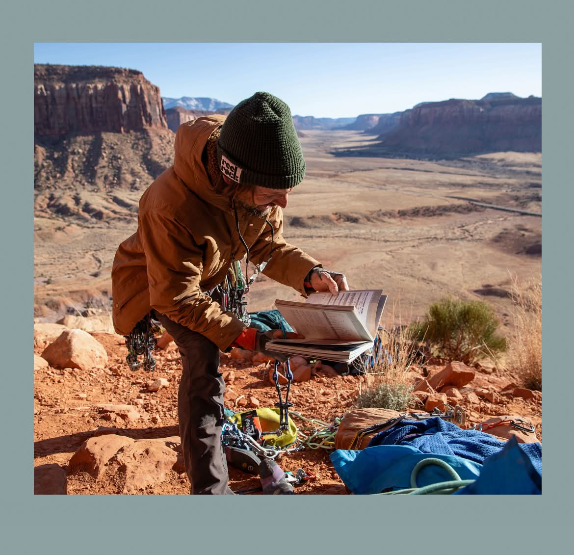 A rock climber looking at a guidebook.