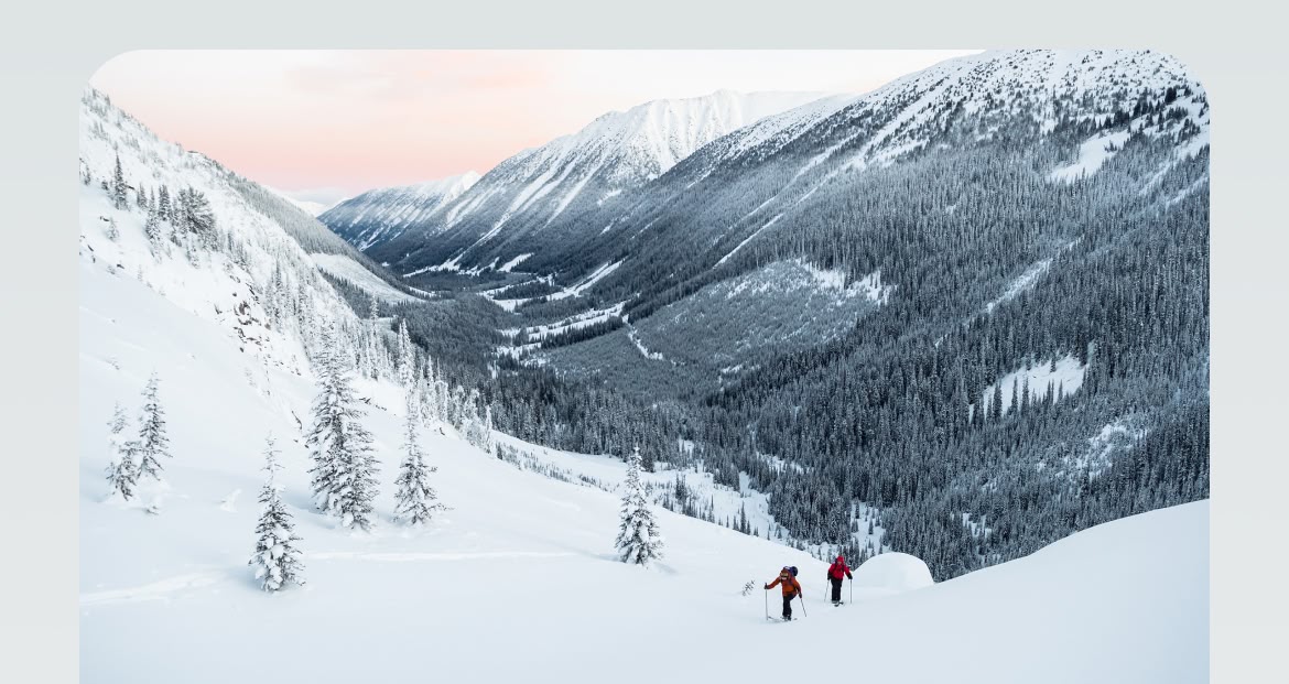 Two backcountry snowboarders hiking uphill.