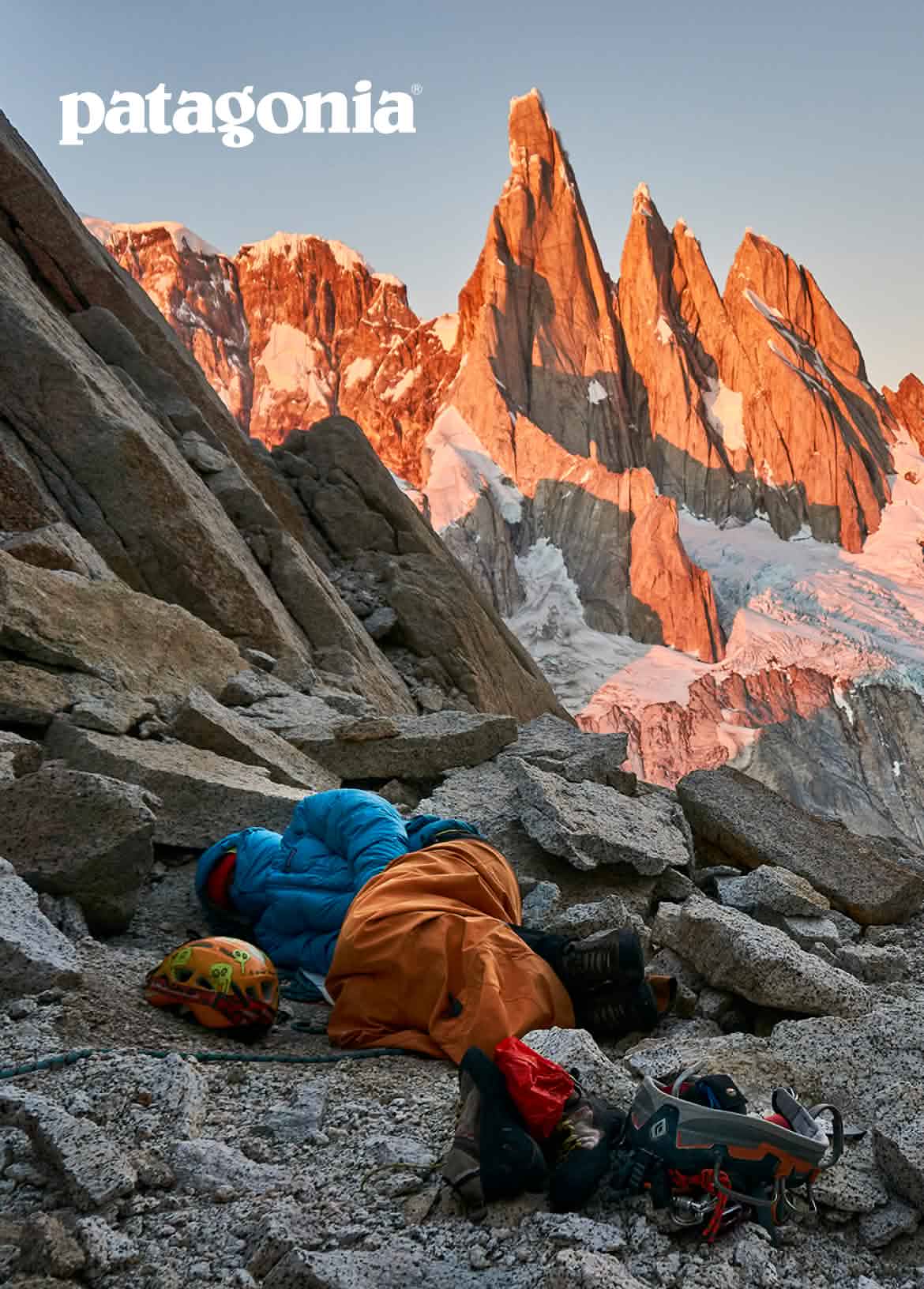 Patagonia. A person sleeps in a jacket on a rock ledge.