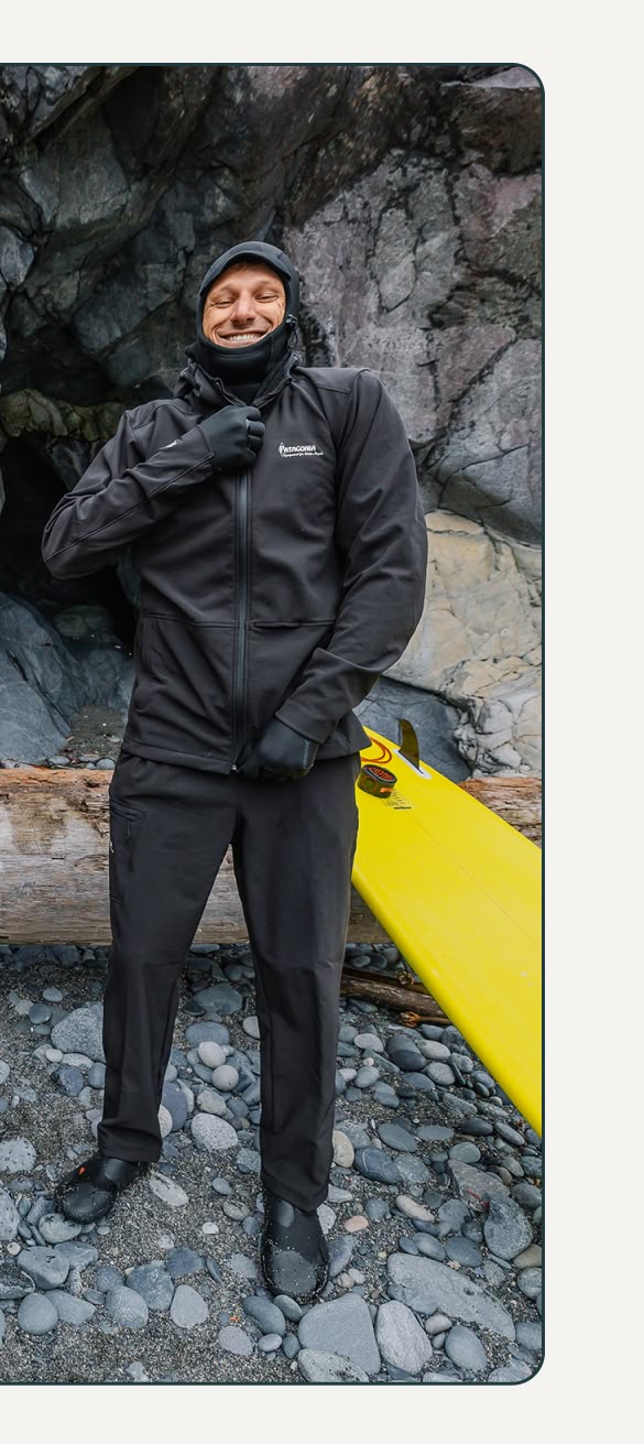 A surfer zips up the Hydropeak Stretch Thermal Hoody over their wetsuit.