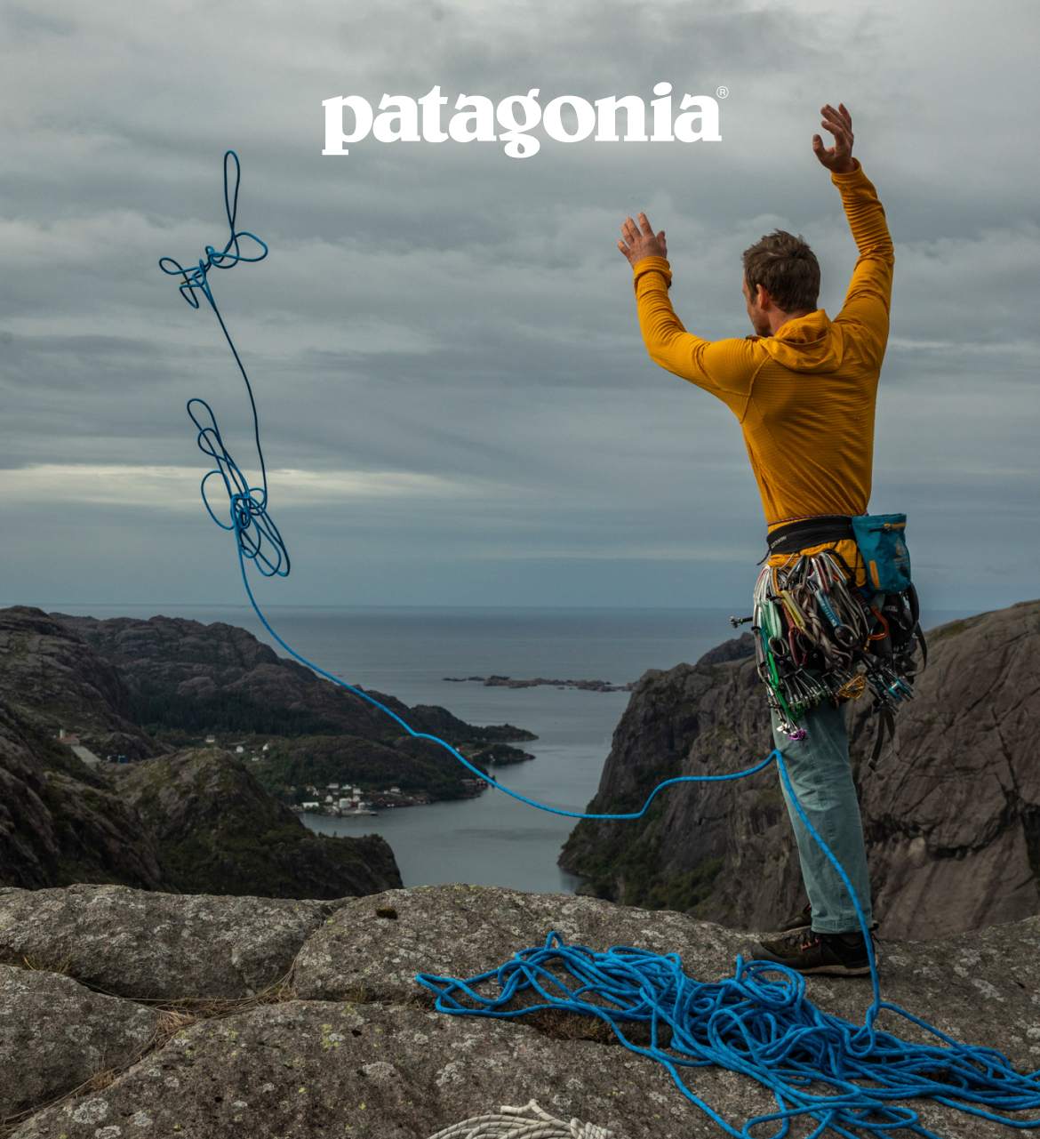 Patagonia. Photo of a climber throwing their rope off the top of a cliff. 