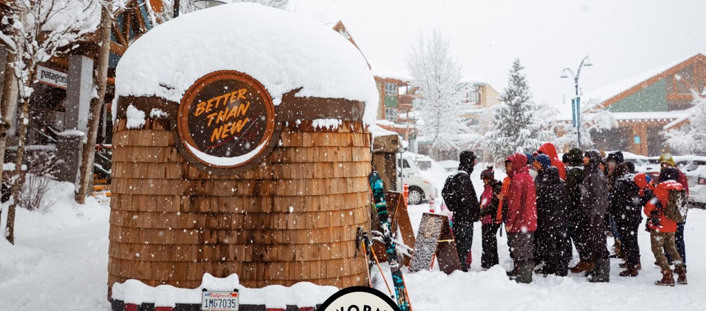 People gather in front of a Worn Wear mobile repair trailer in the snow.